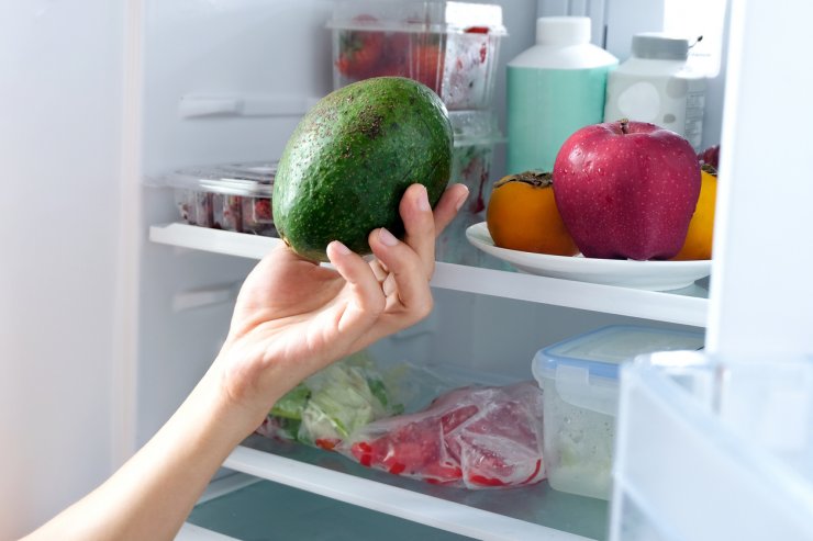 Removing whole avocado from refrigerator.