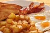 Breakfast spuds with eggs, bacon, and toast.