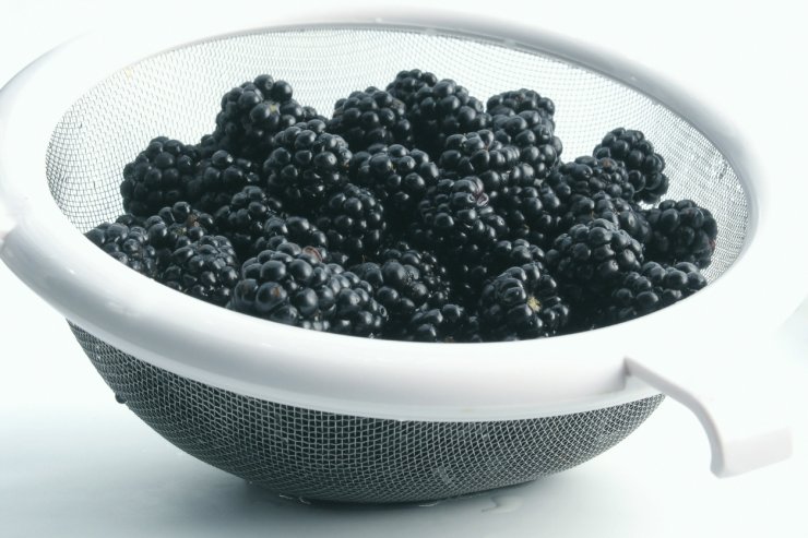 Blackberries in a fine mesh sieve.