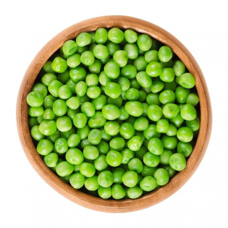 Shelled peas in wooden bowl.