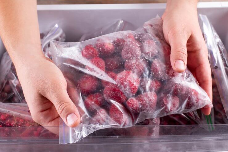 Frozen strawberries. Frozen berries and fruits in a plastic bag in refrigerator