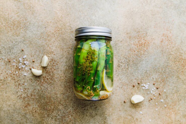 op view of a glass jar with pickled asparagus and spices