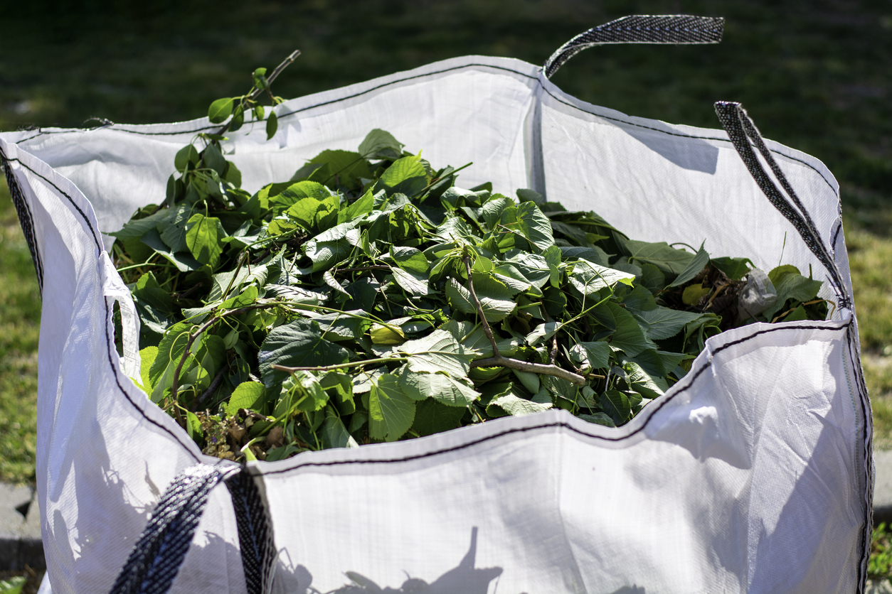 Big white bag with organic green garden waste.