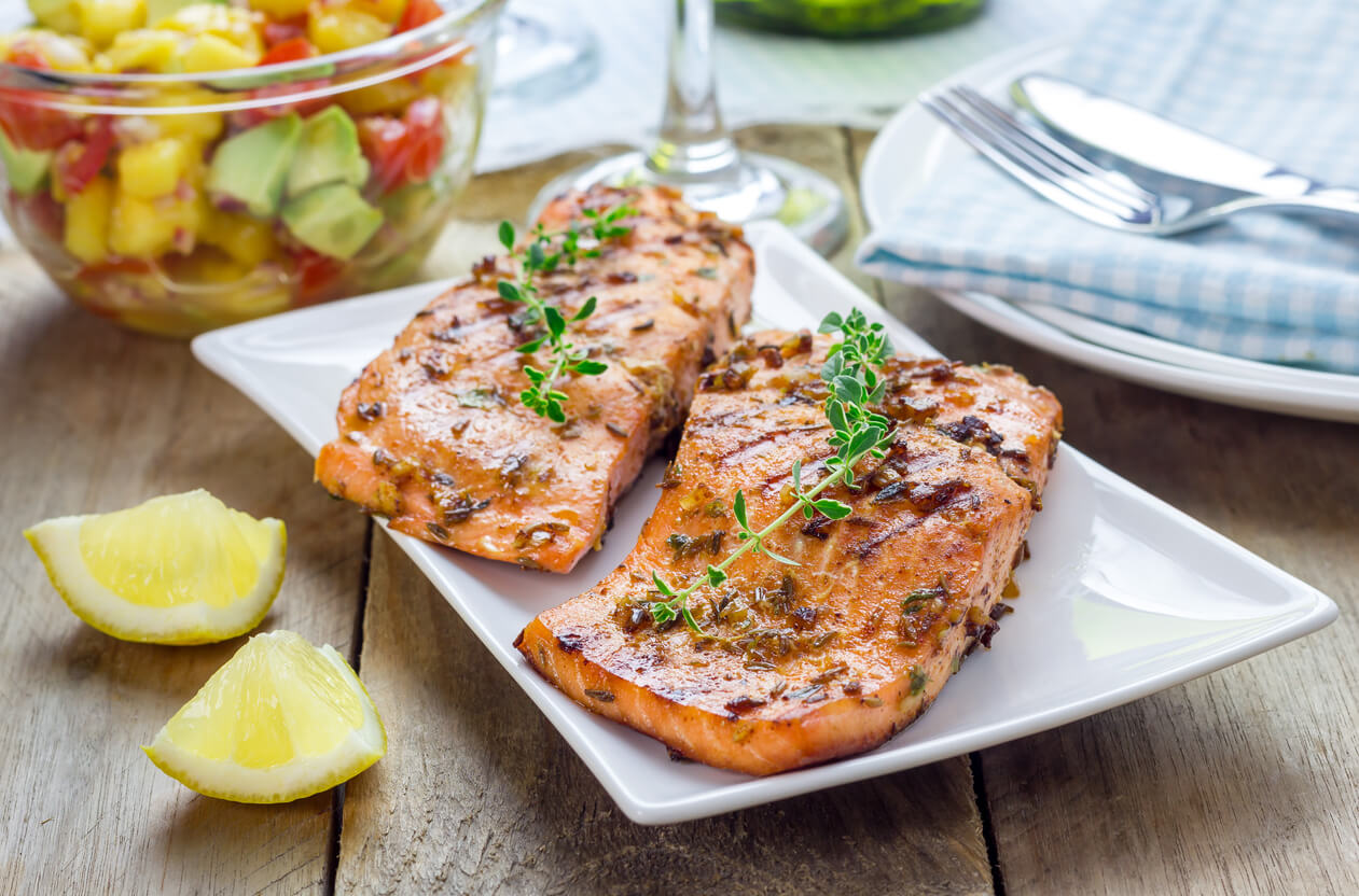 Spice grilled salmon with mango-avocado salsa on a white plate