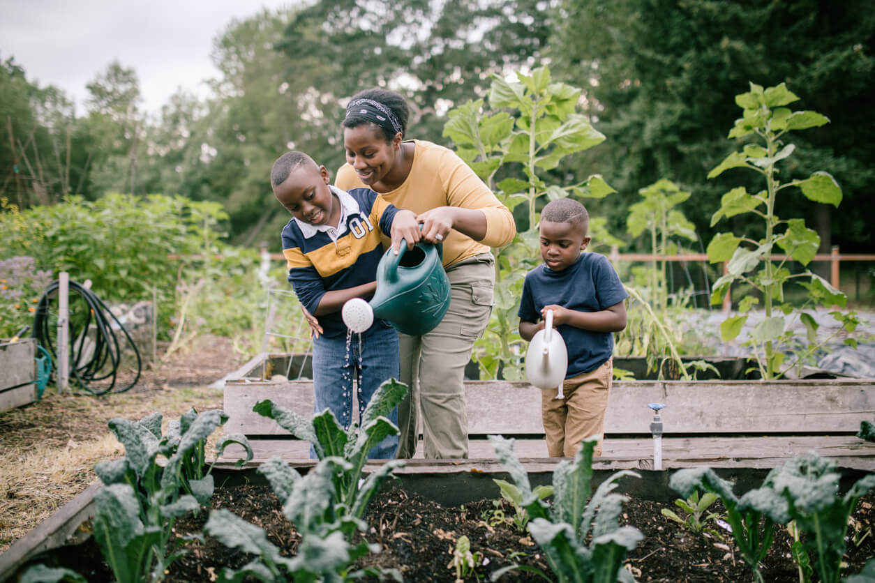 Mother Gardening With Her Children