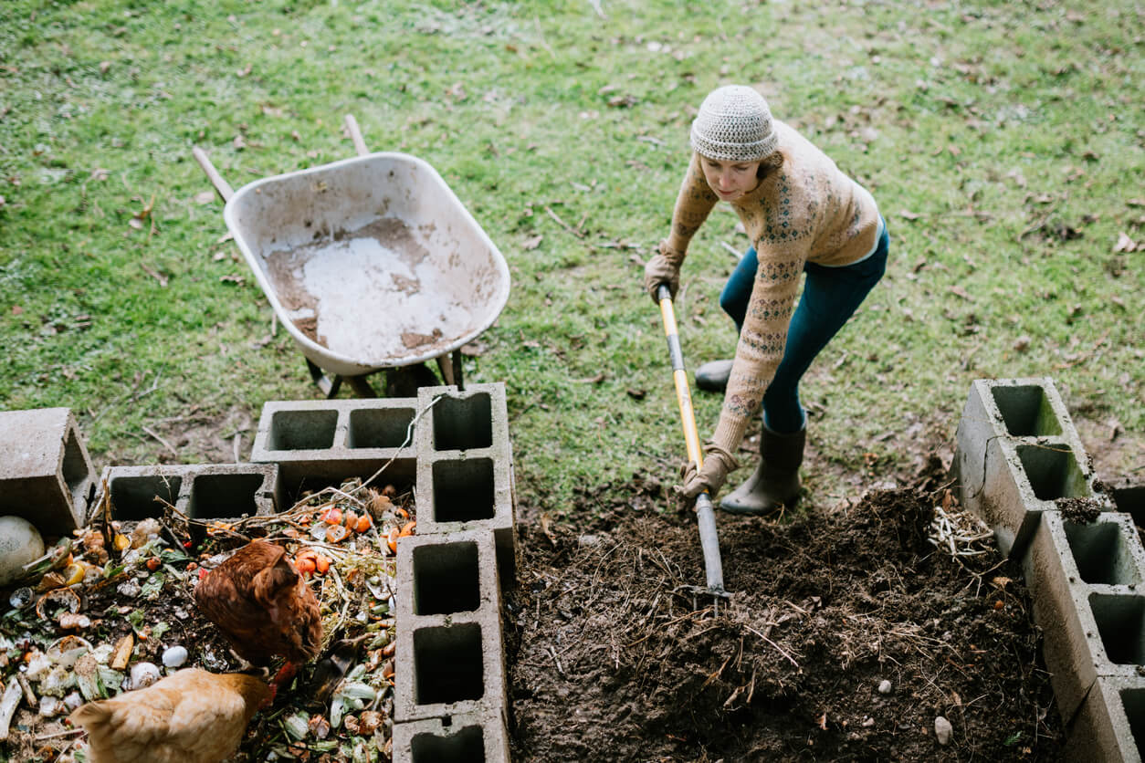 Woman Scooping Nutrient Rich Compost into Wheelbarrow