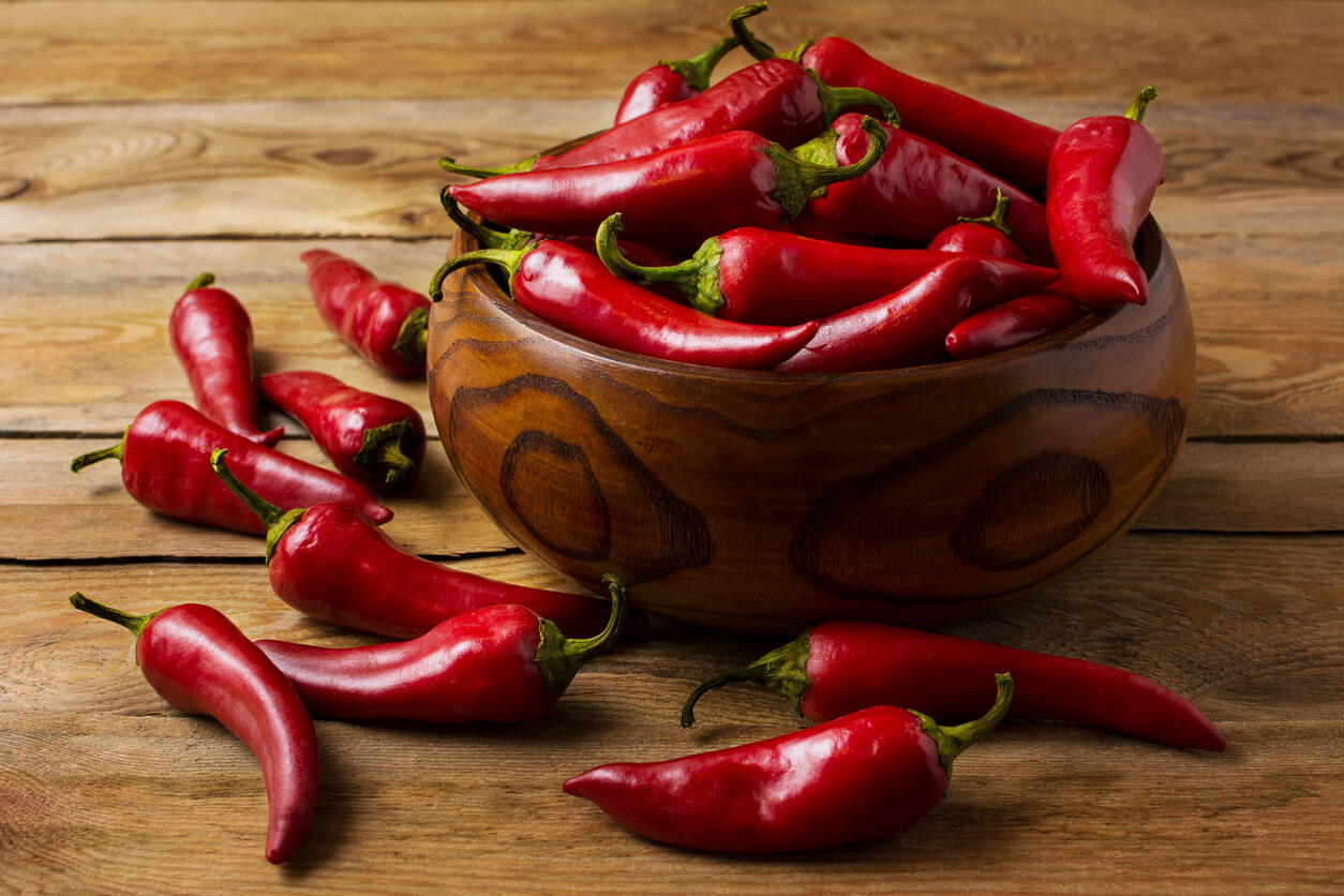 Red hot chile pepper in wooden bowl