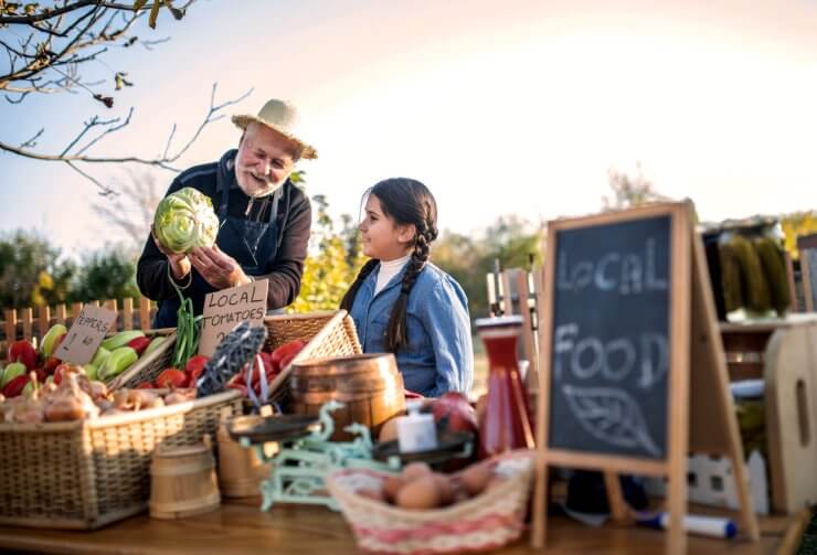 Farm workers selling homegrown groceries on a market stand