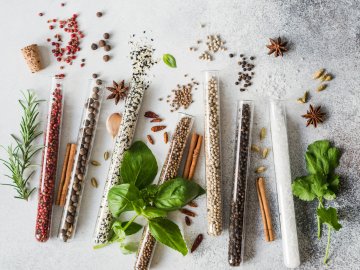 Various spices in glass test tubes and fresh herbs