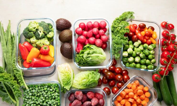 Boxes with fresh raw vegetables on table.